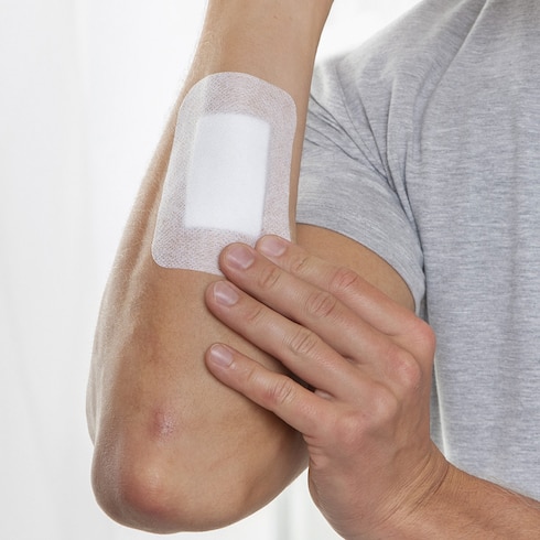 Inspectie van Leukomed absorberend wondverband van Leukoplast op arm