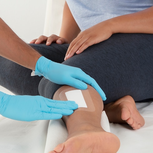 Inspectie van Leukomed T plus verbandmiddel van Leukoplast op been